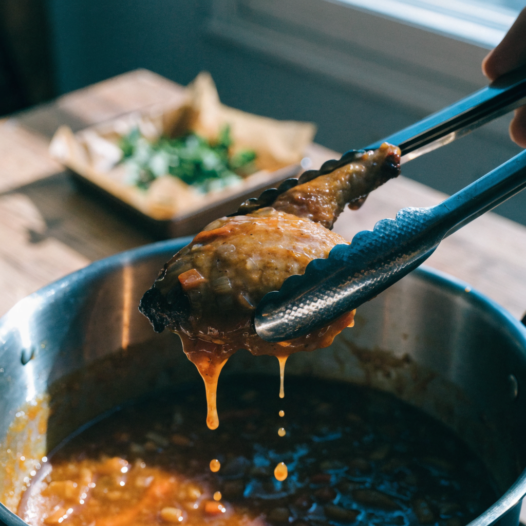 Close-up of stovetop brown stew chicken with glossy braise